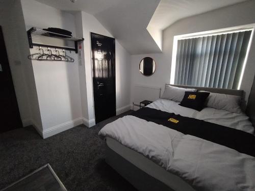 布莱克浦Black Ocean Holiday Apartments的一间卧室设有一张大床和一个窗户。