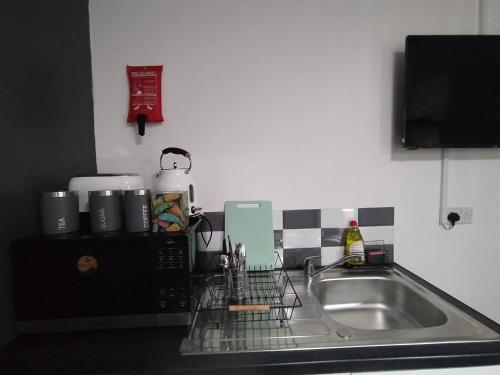 布莱克浦Black Ocean Holiday Apartments的厨房柜台设有水槽和微波炉