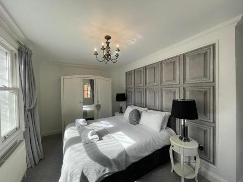 LincolnshireCastle View House的卧室配有一张白色大床和吊灯。