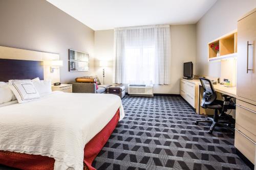 吉尔福特吉尔福德万豪广场套房酒店的酒店客房设有一张大床和一张书桌。