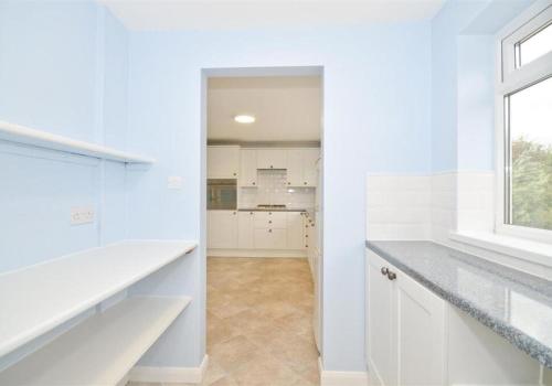 海景城Seasalt and Seasalt Cabin, Seaview的白色的厨房配有白色橱柜和窗户