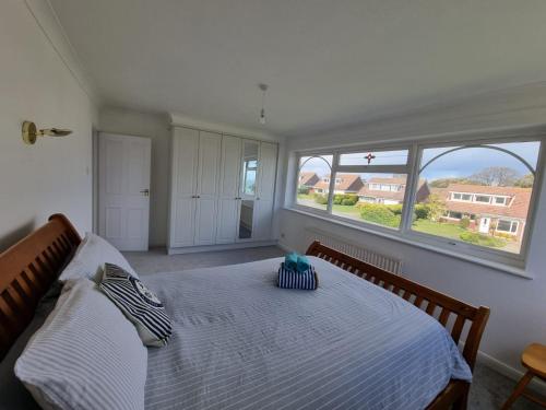 海景城Seasalt and Seasalt Cabin, Seaview的一间卧室设有一张大床和两个窗户