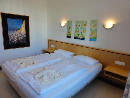 宾茨Ferienwohnung im Dünenpark的卧室配有白色床和毛巾
