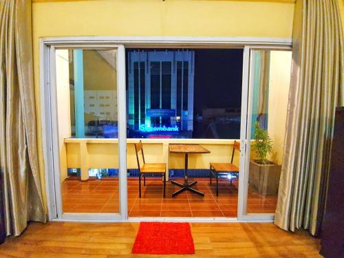 Ban NongdouangNo Name Studios的客厅设有一张带桌子的大型滑动玻璃门