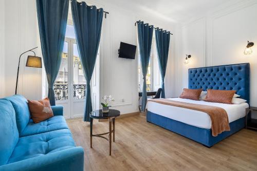 里斯本Lisbon 5 Hotel的一间卧室配有蓝色的床和蓝色的沙发