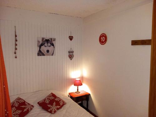 欧特吕斯Appartement chalet en plein centre des Saisies的一间卧室配有一张床和一张带台灯的桌子