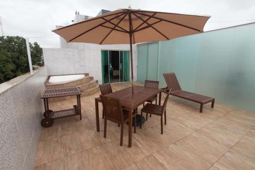 阿尔塔米拉Hotel Vale Do Xingu的庭院里配有一张木桌和椅子及遮阳伞