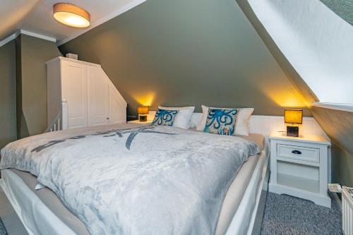 凯图姆Gemütliche Wohnung unter Reet mit Pool und Sauna in Keitum的一间卧室配有一张带蓝色枕头的大床