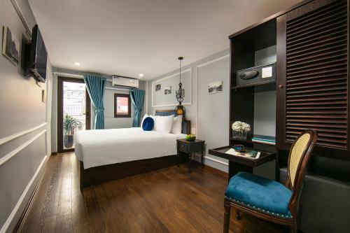 河内La Renta Hotel & Spa的卧室配有1张床、1张桌子和1把椅子