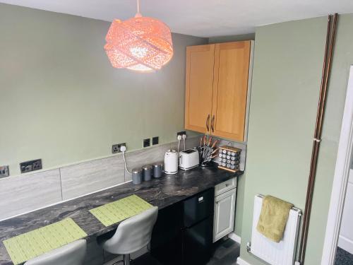 莱斯特CozyComfy Apartment Leicester的厨房配有水槽和带椅子的柜台。