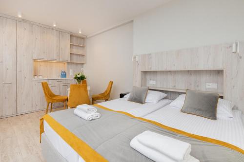 格但斯克Villa Angela - BEZPŁATNY PARKING - FREE PARKING的一间卧室配有两张带毛巾的床