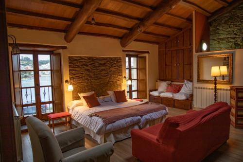 纳维亚Casa Ría de Navia的一间卧室配有一张床、一张沙发和一把椅子