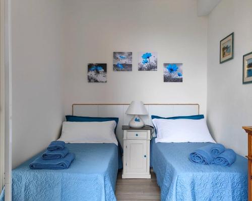 包内伊Dommu de Anna Murru的卧室设有两张床铺,配有蓝色床单