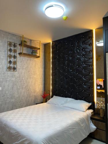 巴淡岛中心Batam Three Bedrooms Apartment - One Residence 2AG -的一间卧室配有一张大床和黑色床头板