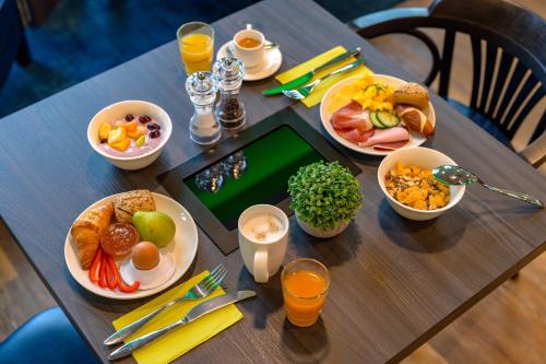 基尔ibis Styles Kiel City的一张带早餐食品的桌子和一张平板电脑