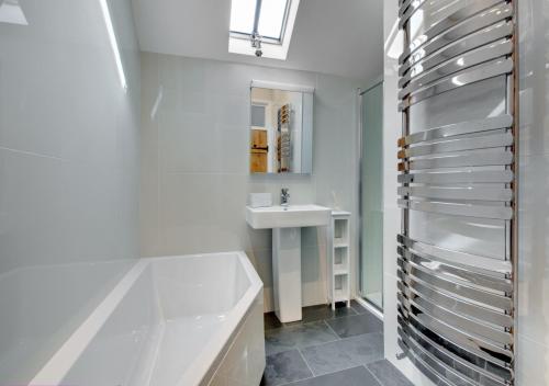 Llanfihangel-geneuʼr-glynOnnen的浴室配有白色浴缸和水槽