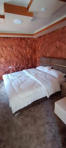 瓦迪穆萨Asem Studio apartment的砖墙房间内一张大白色的床
