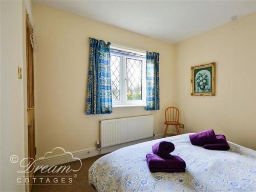 多切斯特Frome Lodge House的一间卧室配有一张大床,上面有紫色枕头