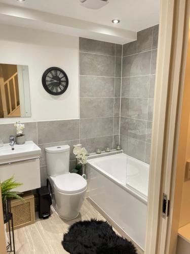 曼彻斯特Cosy Bedrooms的浴室配有卫生间、浴缸和水槽。