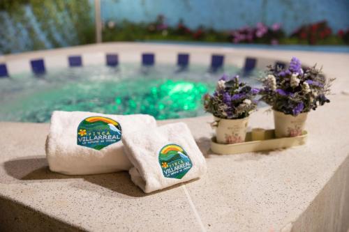 卡利Finca Villarreal的游泳池旁的两条毛巾和鲜花