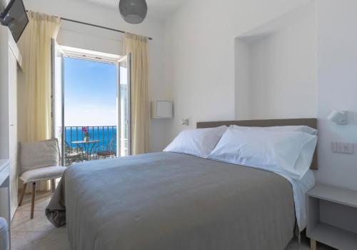 卡普里普罗拉酒店的一间卧室配有一张床,享有海景