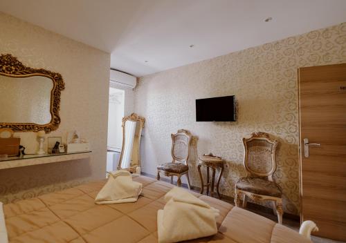 雅典ROH Suites的一间卧室配有一张床、两把椅子和镜子