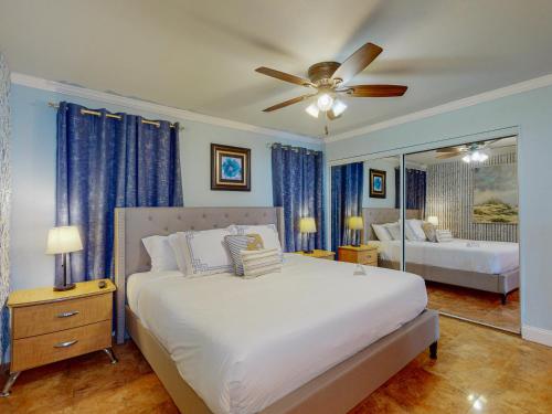 帕德雷岛MP217 Gulf view condo with Boardwalk to Beach的一间卧室配有一张带吊扇和镜子的床
