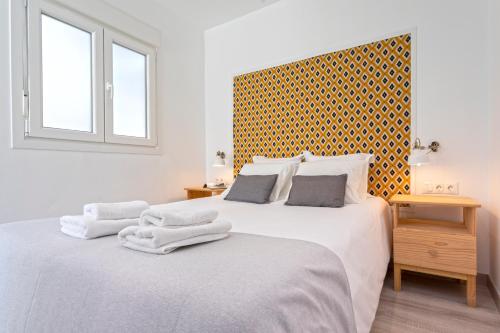 马拉加Livemalaga Pedregalejo的白色卧室配有两张带毛巾的床