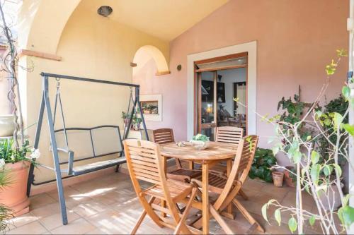 UrzuleiB&B Su Biancu - Sardinian Experience的庭院配有木桌和椅子