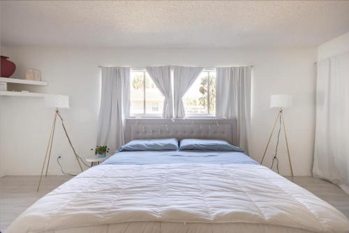 皮尔斯堡Serenity Studio的白色卧室内的一张大床,设有窗户