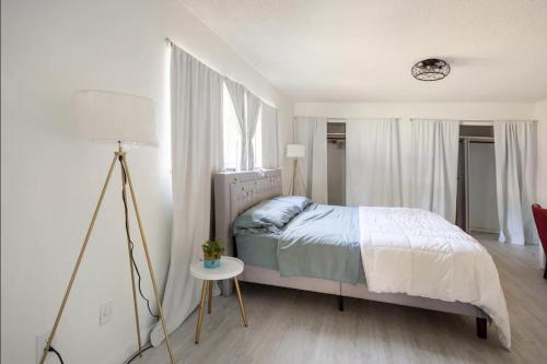 皮尔斯堡Serenity Studio的一间卧室配有一张床和一张带台灯的桌子