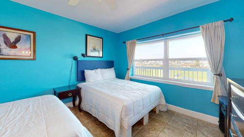 阿兰瑟斯港SIV10 Beautiful Condo, Shared Pool, Close to Beach的蓝色的卧室设有床和窗户