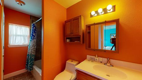 阿兰瑟斯港SIV10 Beautiful Condo, Shared Pool, Close to Beach的橙色浴室设有水槽和镜子