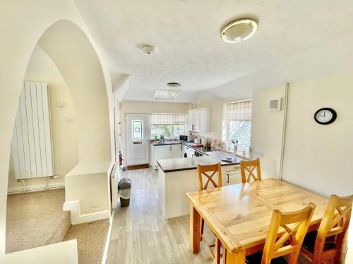 特雷杜尔Bay View Apartment - Trearddur Bay的厨房以及带木桌的用餐室。