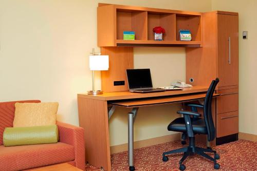 布卢明顿TownePlace Suites by Marriott Bloomington的办公室配有带笔记本电脑和椅子的书桌