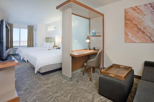 威奇托Springhill Suites by Marriott Wichita East At Plazzio的配有一张床和一张书桌的酒店客房