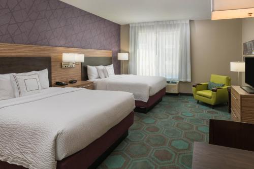 绍姆堡芝加哥绍姆堡万豪广场套房酒店的酒店客房,配有两张床和椅子