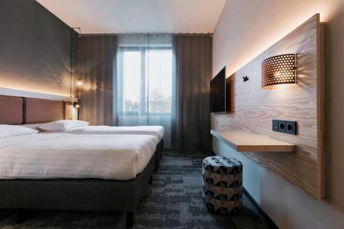 达姆施塔特Moxy Darmstadt的酒店客房配有两张床和一张书桌