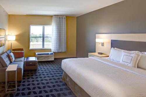 瓦尔汉TownePlace Suites by Marriott Wareham Buzzards Bay的酒店客房设有一张大床和一张沙发。