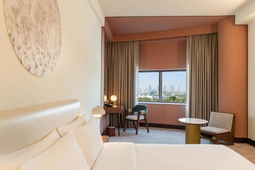 迪拜艾美航道酒店的配有一张床和一张书桌的酒店客房