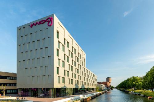 乌得勒支Moxy Utrecht的河岸边的建筑,上面有wpx标志