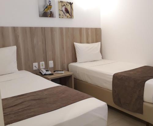 圣安东尼奥-迪热苏斯Pena Branca Hotel e Eventos的酒店客房带两张床和电话