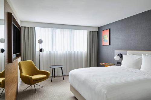 卡迪夫万豪加的夫度假酒店的配有一张床和一把椅子的酒店客房