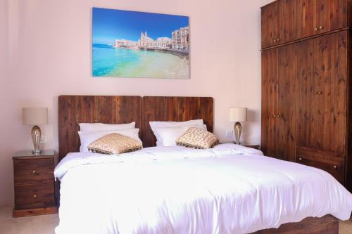 圣朱利安斯玛多尼纳民宿的一间卧室配有一张大床和木制床头板