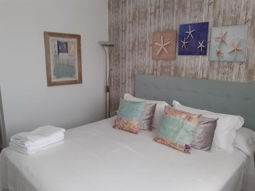 加的斯Torre D'Arenas, playa Victoria, piscina y parking的卧室配有带枕头的白色床