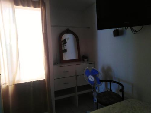 蓬塔赫尔莫萨El Refugio的一间卧室配有梳妆台、镜子和椅子