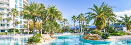 德斯坦5 Star Resort 6th fl 2BR 2 BATH King Suite Shuttle Pools, restaurants & more的棕榈树和椅子的度假村的游泳池