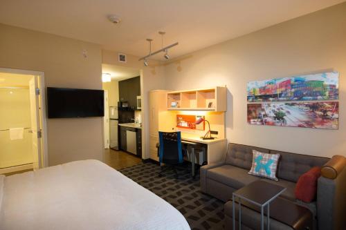林垦林肯北万豪广场套房酒店的酒店客房配有一张床、一张沙发和一张书桌。