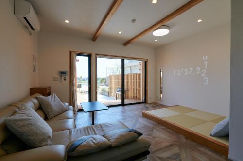 淡路Rush Awaji - Seaside Holiday Home - Self Check-In Only的客厅配有沙发和桌子