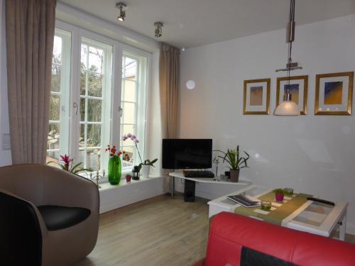 吕讷堡海洋光辉公寓的客厅配有红色沙发和电视